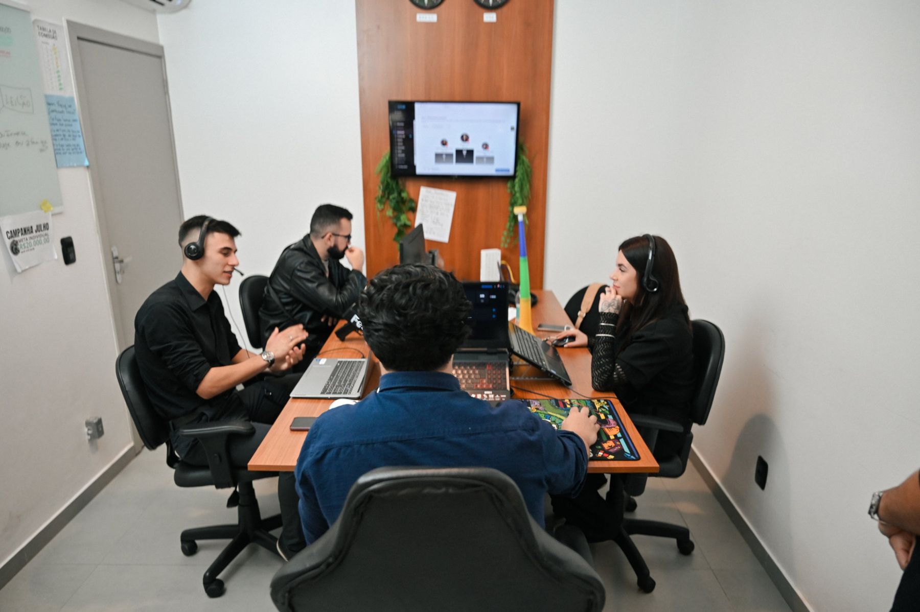 Time de agendamento trabalhando com headsets no escritório